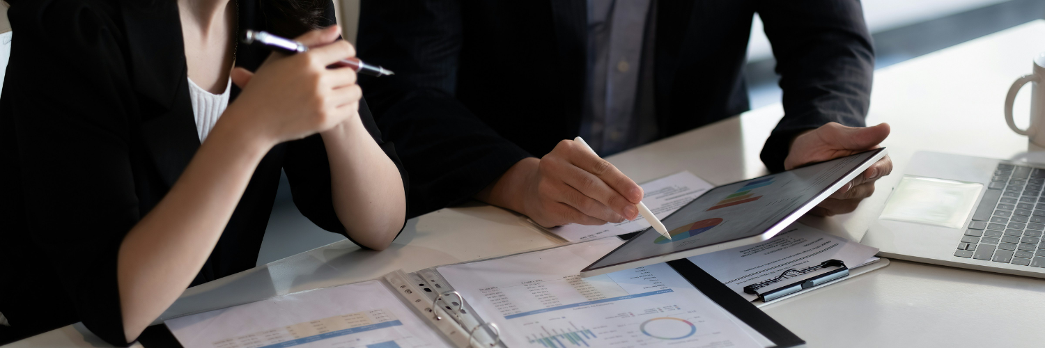 A man and a women discussing something business-related with only their hands pictured.